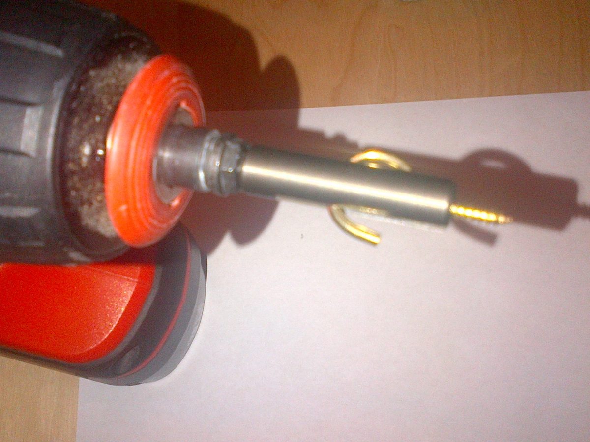 EasyHook Driver chucked into a cordless drill, driving a brass cup hook